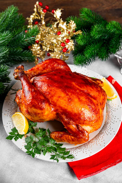 istock Whole baked chicken in sauce with paprika on a plate and a Christmas table setting vertical photo 1340628024