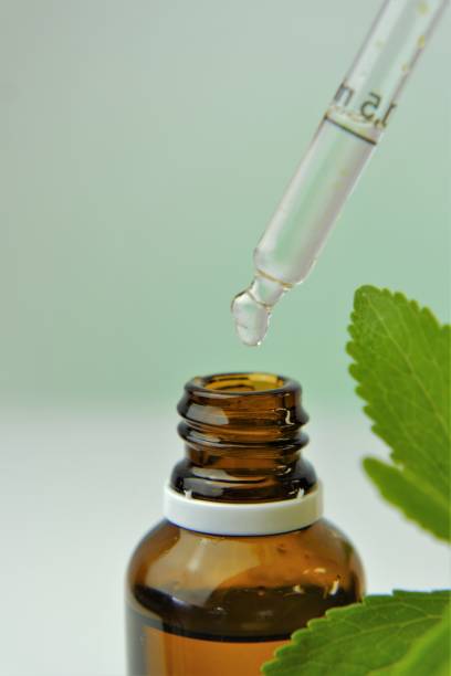 istock Stevia rebaudiana branch and bottle with stevia extract on blurred background. Stevia liquid.Natural vegetable sweetener. Healthy food 1340631653