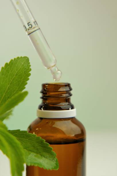 istock Stevia rebaudiana branch and bottle with stevia extract on blurred background. Stevia liquid.Natural vegetable sweetener. Healthy food and food for weight loss. 1340631654