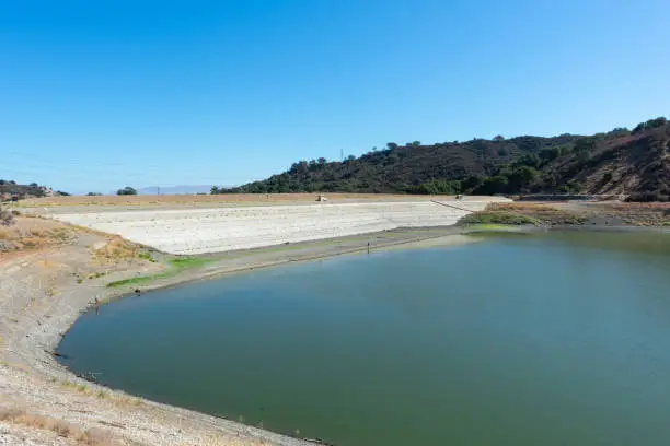 Stevens Creek reservoir at 12 percent capacity in September 2021. Tall concrete dam of almost dried, low water level Stevens Creek reservoir in San Francisco Bay Area, California
