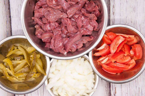 istock Sliced beef or pork meat with fresh vegetables top view 1340632803