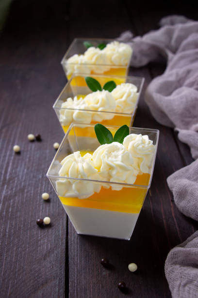 panna cotta de naranja, delicioso postre italiano con crema batida, postre de porción en vasos de plástico transparente. tabla de madera marrón, alimentación saludable, postre saludable, fondo de postre italiano - panna cotta dessert italian culture cream fotografías e imágenes de stock