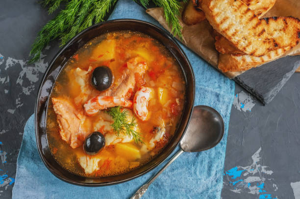 istock Seafood soup, salmon and cod with potatoes. Served with lemon and olives. Close up 1340640371