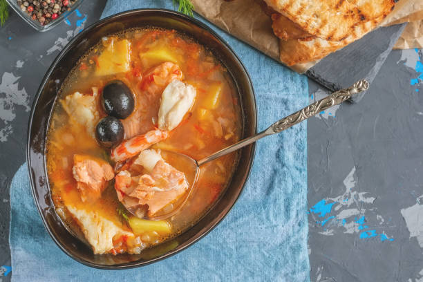 istock Seafood soup, salmon and cod with potatoes. Served with lemon and olives. Close up 1340640384