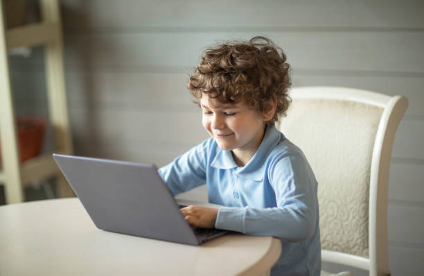 istock curly boy sitting with a laptop 1340641959