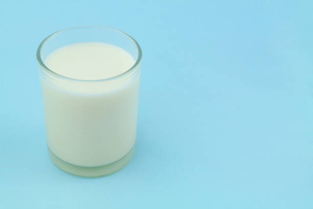 istock Fresh milk in glass on blue background 1340642034