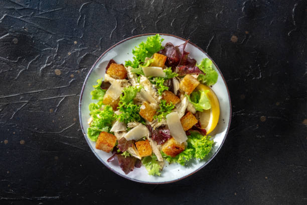 istock Chicken Caesar salad, overhead shot on a black background 1340644318