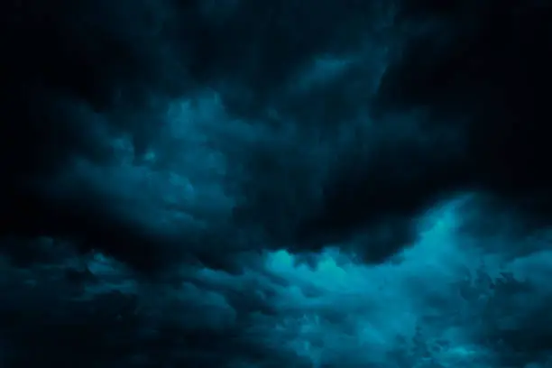 Dramatic blue green sky. Gloomy heavy thunderclouds. Dark teal sky background with copy space for design.