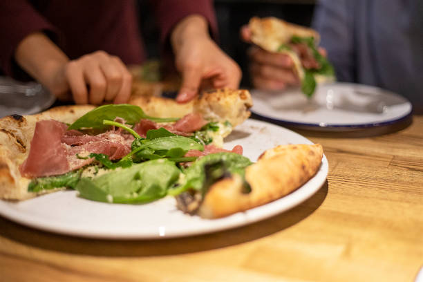 istock grabbing a hot pizza with prosciutto spinach and parmesan close-up, horizontal 1340648216