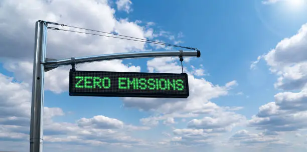 Road information board with text ZERO EMISSIONS on a background of blue sky. Clean mobility concept