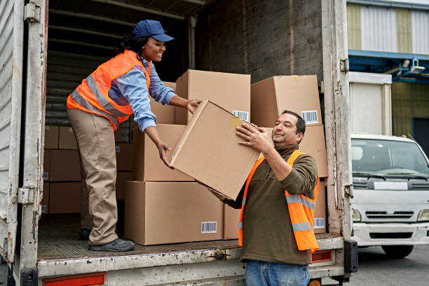 istock Loading Dock Worker Handing Box to Smiling Truck Driver 1340649477