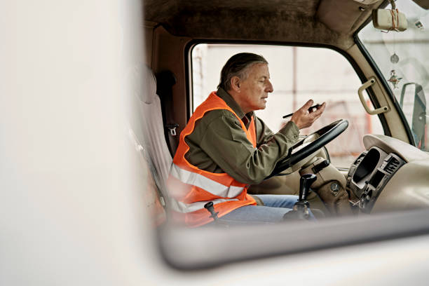 mężczyzna trucker na początku lat 60. przy użyciu telefonu w kabinie - truck driver truck driver driving zdjęcia i obrazy z banku zdjęć