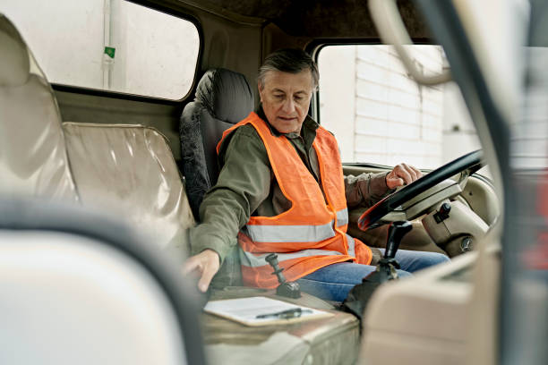 istock Senior Truck Driver Checking Delivery Details in Cab 1340649700