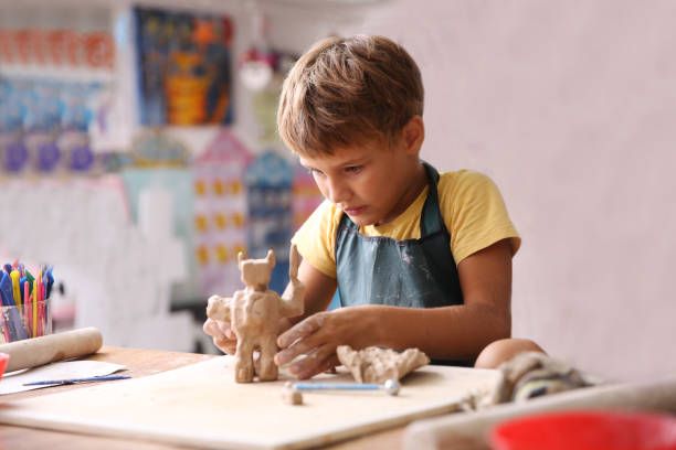 Kid sculpts clay crafts pottery school. stock photo