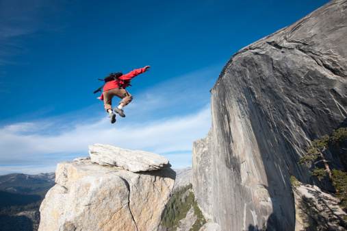 A man jumping in air during his hike