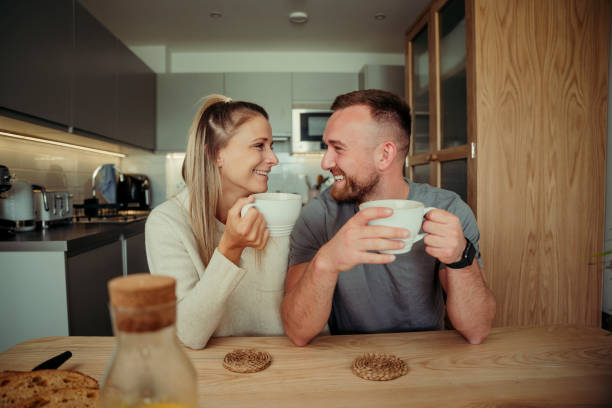 istock Caucasian happy couple drinking coffee at kitchen table 1340658783