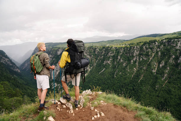 istock Group of friends with backpacks doing trekking excursion on mountain 1340659050