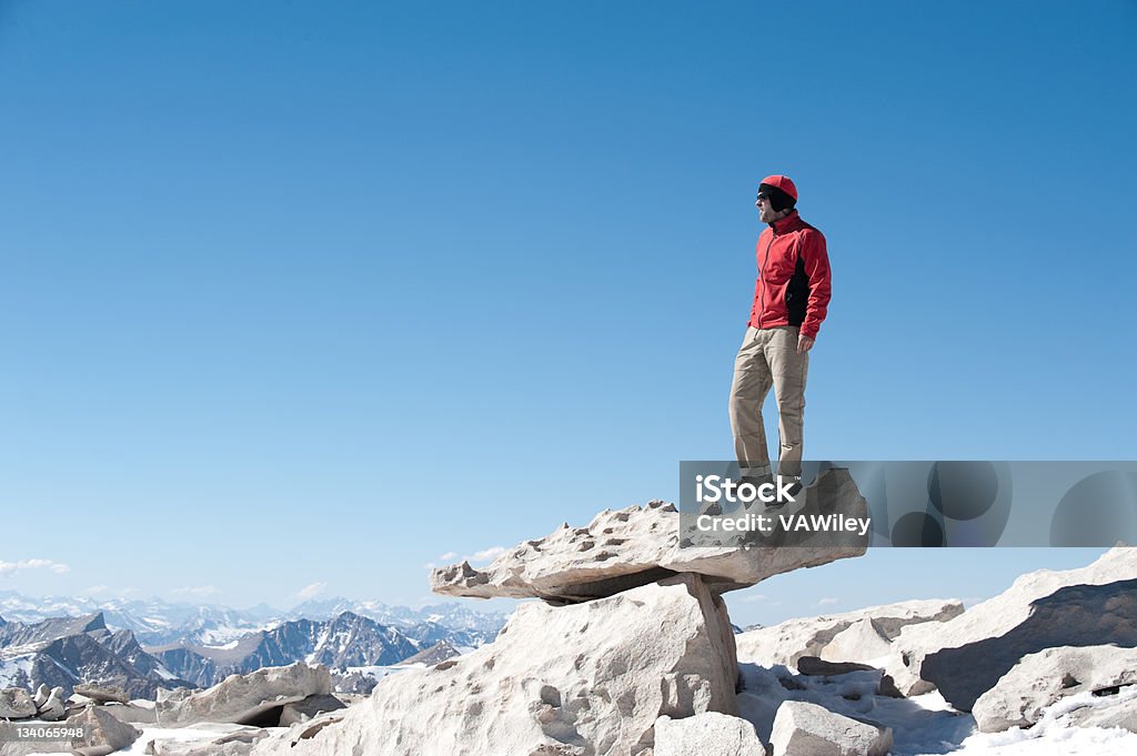 on the top A man standing on a rock on the summit of a mountain Athlete Stock Photo