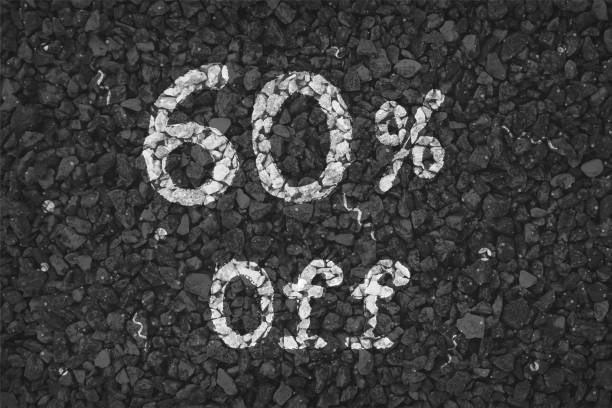 istock Black  and white coloured pebbles making a  rustic poster with text 60 % Off painted on gravel road with small swirls pattern, vector backgrounds 1340661045