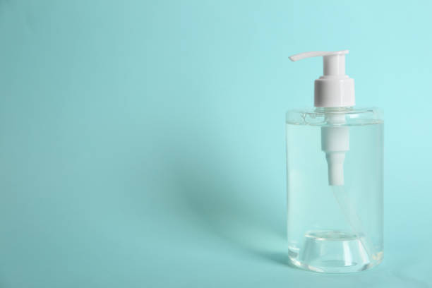 istock Dispenser bottle with antiseptic gel on light blue background. Space for text 1340661065