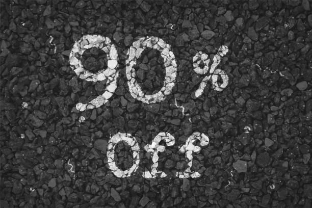 istock Black  and white coloured pebbles making a  rustic poster with text 90 % Off painted on gravel road with small swirls pattern, vector backgrounds 1340661110
