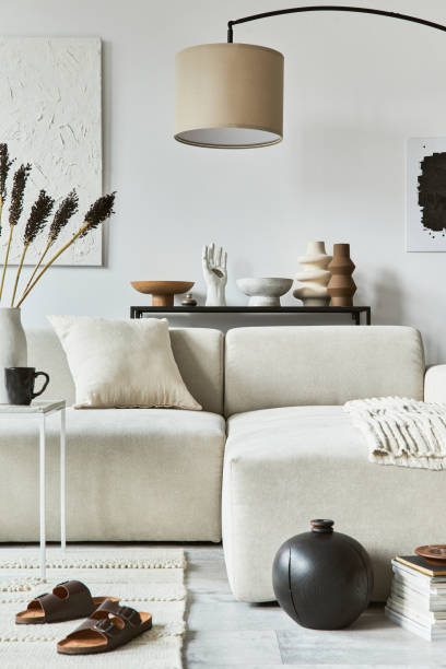 istock Creative interior composition of cozy living room with mock up poster frame and structure painting, corner sofa, coffee table, textile and personal accessories. Scandinavian classic style. 1340662397