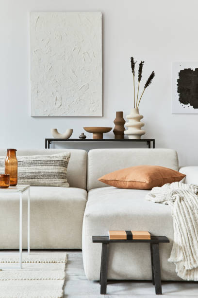 istock Creative interior composition of cozy living room with mock up poster frame and structure painting, corner sofa, coffee table, textile and personal accessories. Scandinavian classic style. 1340662405