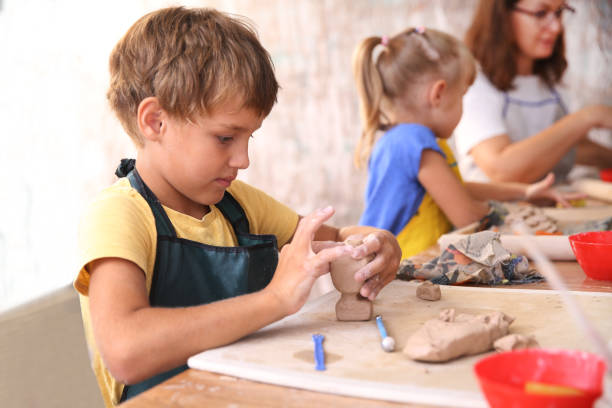 Kids  molded from clay at pottery class. Kids  molded from clay at pottery class. pottery making stock pictures, royalty-free photos & images