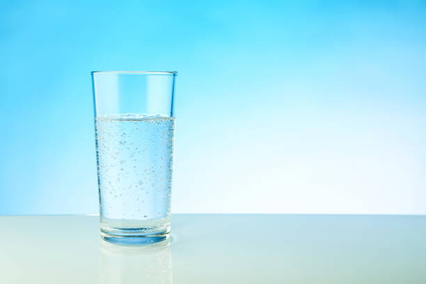 istock glass of sparkling water on blue background with copy space. 1340663891