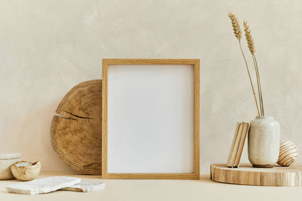 istock Creative composition of cozy minimalistic interior design with mock up poster frame, natural materials as wood and marble, dry plants and personal accessories. Neutral beige colours, template. 1340665242