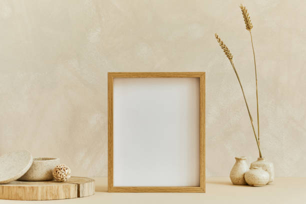 istock Stylish composition of cozy minimalistic interior design with mock up poster frame, natural materials as wood and marble, dry plants and personal accessories. Neutral beige colours, template. 1340665254