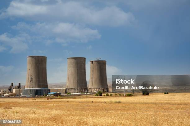 Nuclear Power Plant Cooling Towers Big Chimneys Beside Wheat Field With Partly Cloudy Sky In Kurdistan Province Iran Stock Photo - Download Image Now