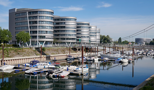 Duisburg, Germany- Sept 14. 2021: The Inner-Harbour district of Duisburg with modern office buildings and some private boats in the foreground.