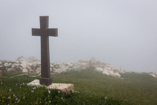Foggy landscape with spooky stone cross, Khvamli Mountain, Georgia, Halloween motif, copy space.