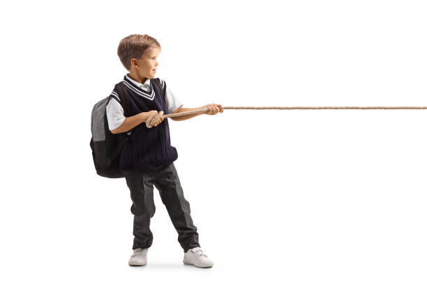 istock Full length profile shot of a little schoolboy pulling a rope 1340669942
