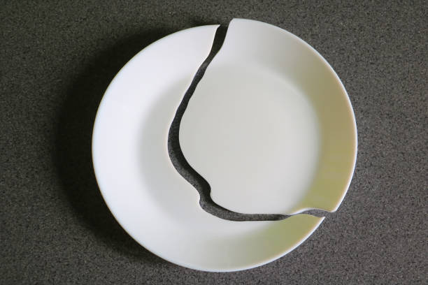 istock View of the broken white plate on the table. 1340670124