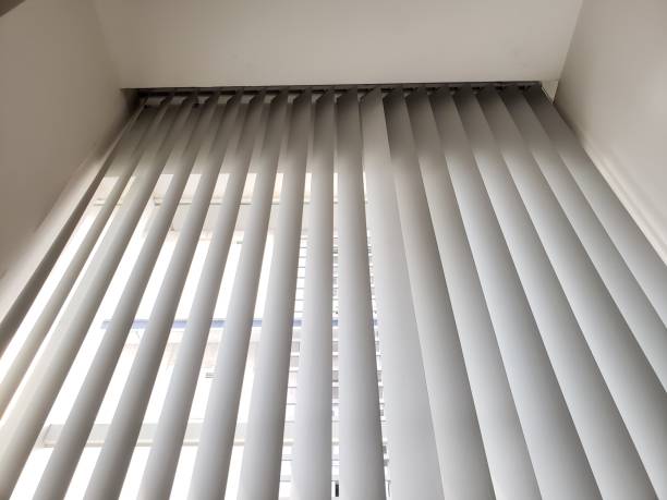 istock Close up white curtains behind a glass window in an office building 1340671393