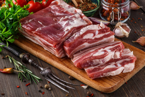 fat bacon on a wooden board. Close-up fat bacon with garlic and spices, homemade lard,Slices of bacon on a cutting Board. Pork meat. stock photo