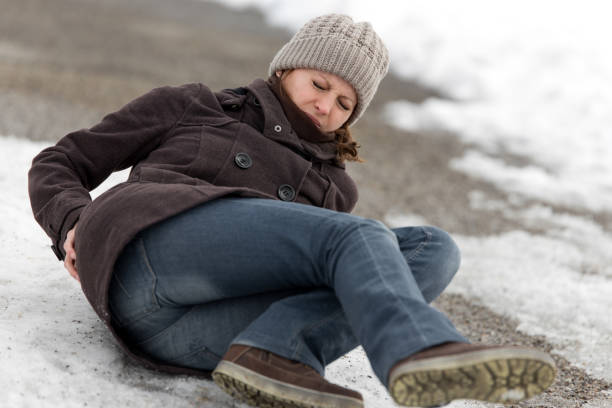 молодая женщина попала в аварию на ледяной дороге с черным льдом - human spine human age horizontal outdoors стоковые фото и изображения
