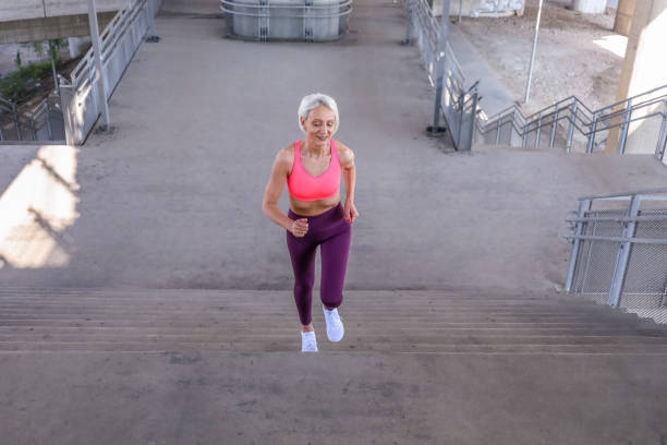 istock Senior athletic woman jogging upstairs 1340675108
