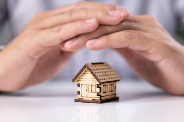 istock Protecting hands over house, Home security and insurance concept 1340675324