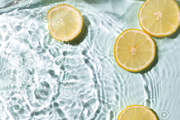 istock Fresh pieces of lemon and clean blue water,bright sunlight.Empty space.Lemons and splashing water as a background 1340675517