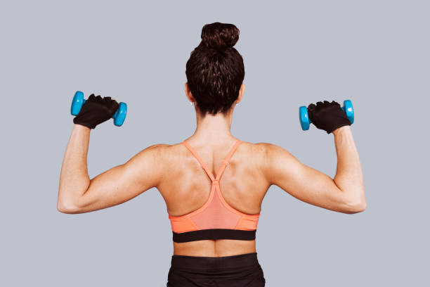 istock Strong woman lifting dumbbells over grey background 1340677073
