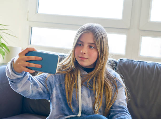 istock Blond kid girl selfie with a window background 1340681173