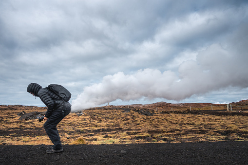 Man posing in front of the geothermal area of Gunnuhver in Iceland.