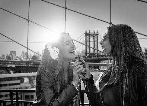 Best friends band girls singing karaoke outdoor at roof terrace in New York photomount