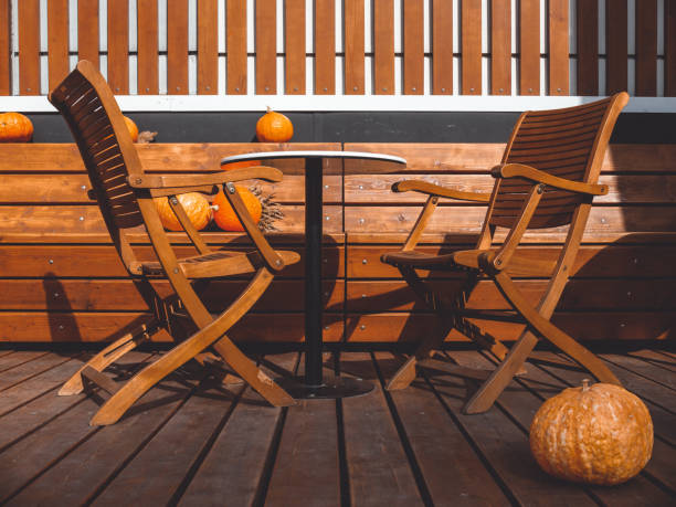 istock Two wooden chairs and a table on a wooden platform with benches 1340685112