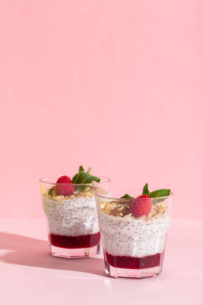 chia seeds vanilla pudding with raspberry, oats musli and mint on rose hard shadow - strawberry blueberry raspberry glass imagens e fotografias de stock