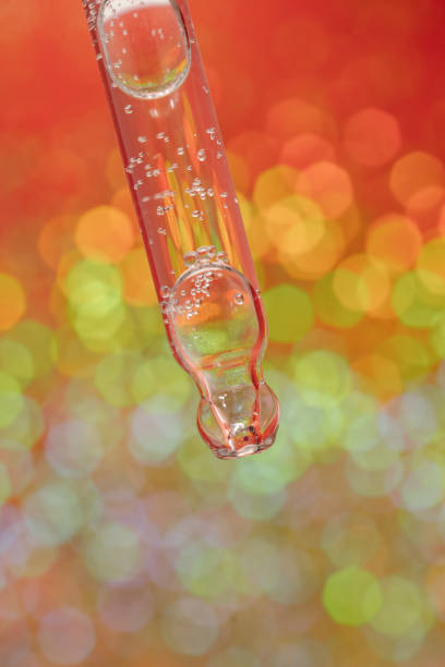 istock Pipette with serum on a red holiday background with bokeh. 1340686651