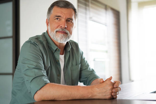 istock Happy attractive mature man sitting at table in kitchen. 1340688226
